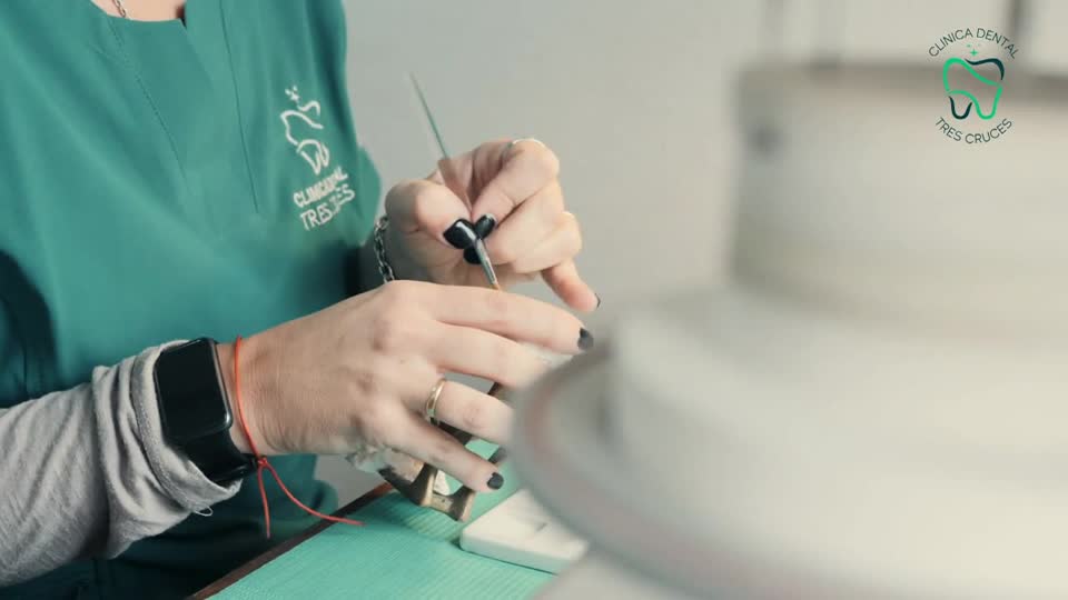 Manos de una laboratorista terminando una pieza